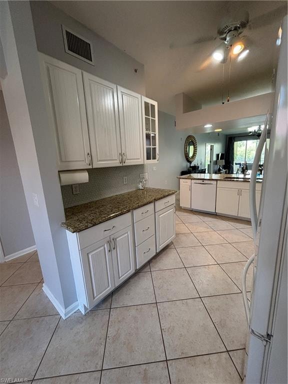 Kitchen featuring white cabinetry, granite countertops, tile flooring, and a tile backsplash
