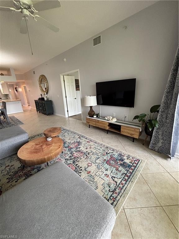 Vaulted ceiling living space featuring tile flooring, a ceiling fan, and recessed lighting