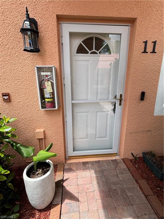 View of exterior entry with stucco siding
