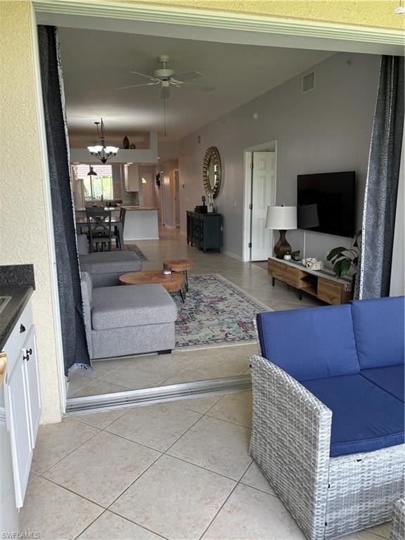 Spacious covered lanai with tile flooring and built-in cabinetry, opening to an interior featuring a ceiling fan, recessed lighting, and tile flooring throughout