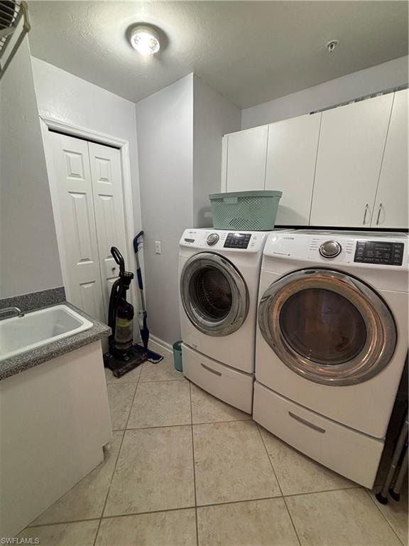 Dedicated laundry area featuring tile flooring, white cabinetry, a utility sink with a speckled countertop, and a double-door utility closet
