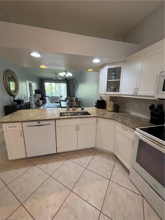 Kitchen featuring white cabinetry, granite countertops, an undermount sink, and tile flooring