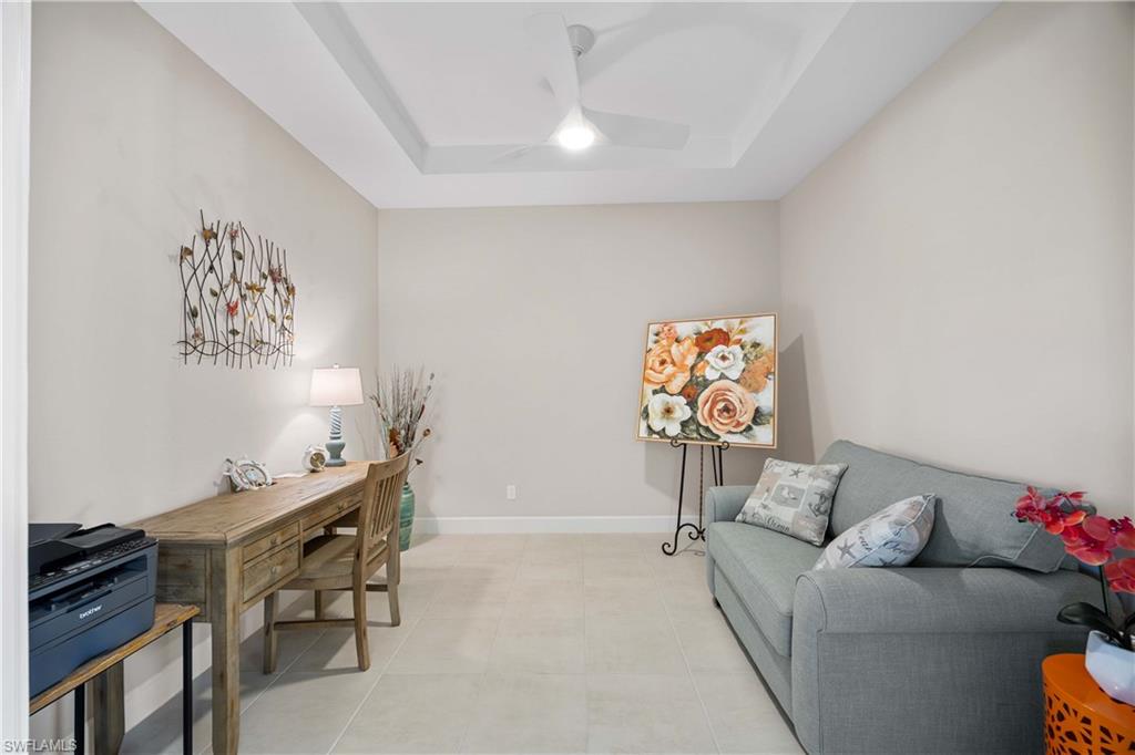 Tiled office space with a raised ceiling and ceiling fan