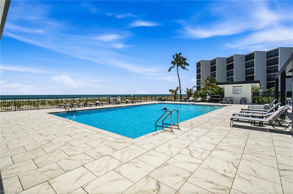 Swimming pool with stainless steel handrails, surrounded by a large paver patio