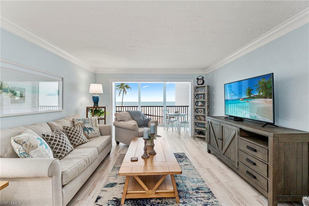 Light-toned wood-finish flooring complements the crown molding and light blue wall color