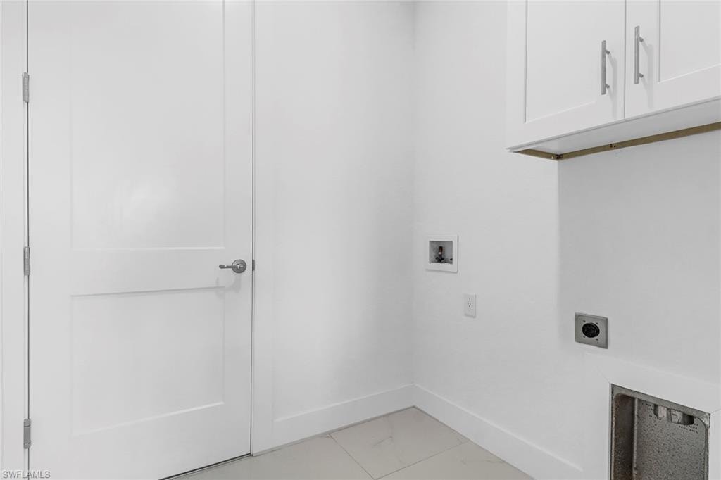 Dedicated utility space featuring white shaker-style cabinetry with brushed nickel hardware