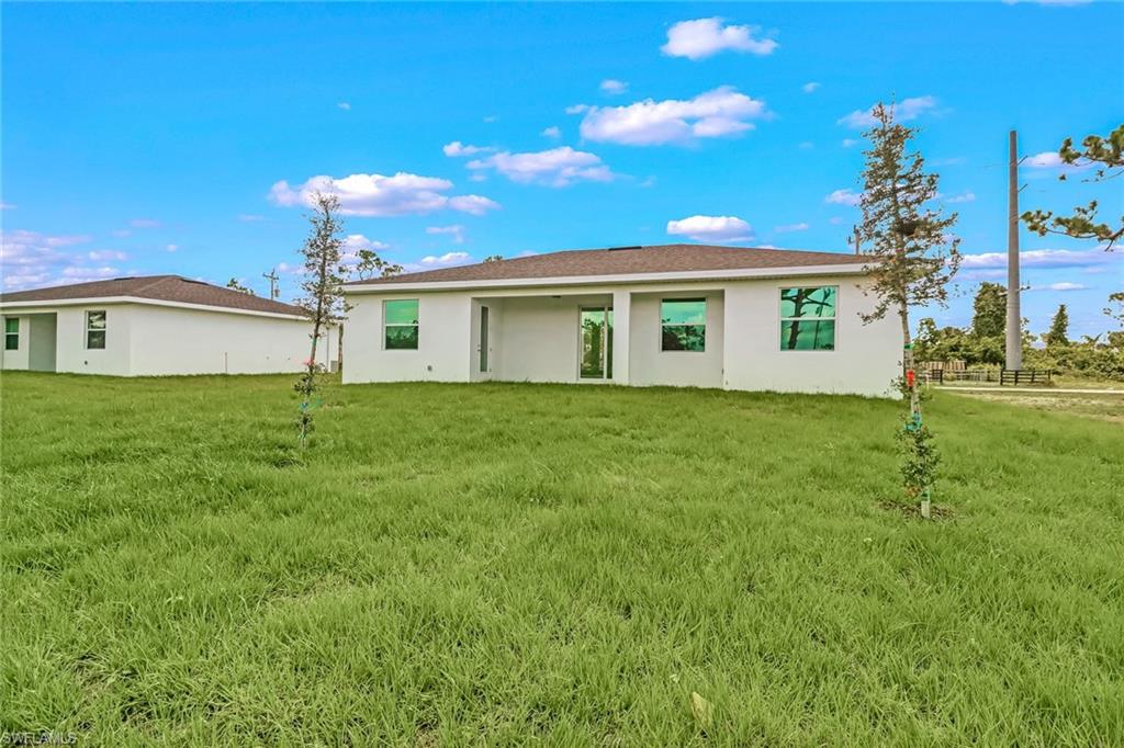 White stucco exterior with a covered patio and green-tinted windows