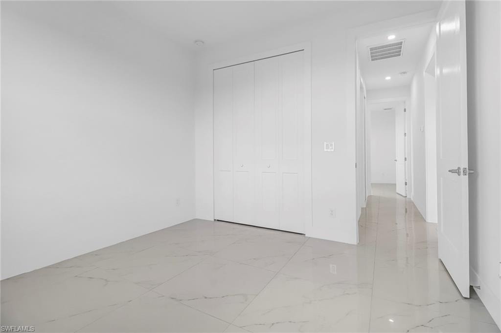 Spacious room featuring large format tile flooring and a bi-fold closet