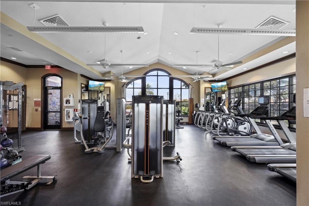 Exercise room featuring ceiling fan, lofted ceiling, and recessed lighting