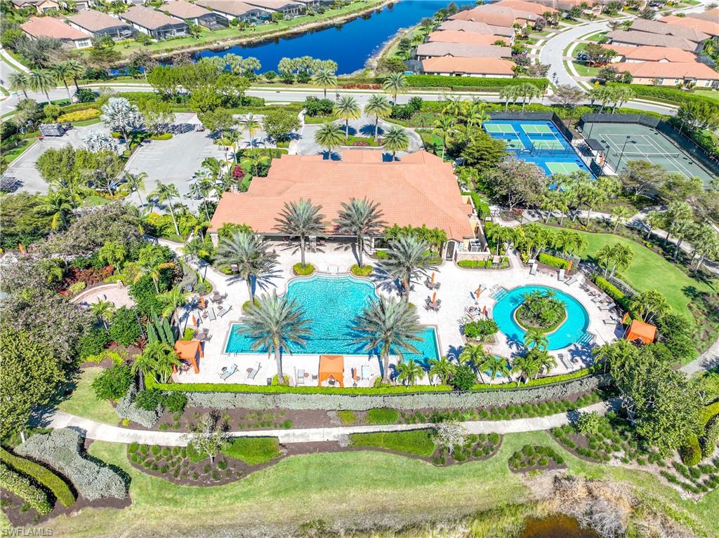 Aerial perspective of suburban area featuring a large body of water and a pool area