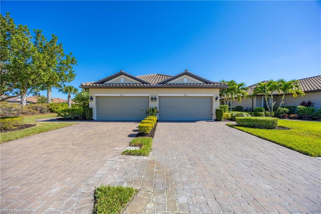 Single story home with stucco siding, decorative driveway, and a tile roof