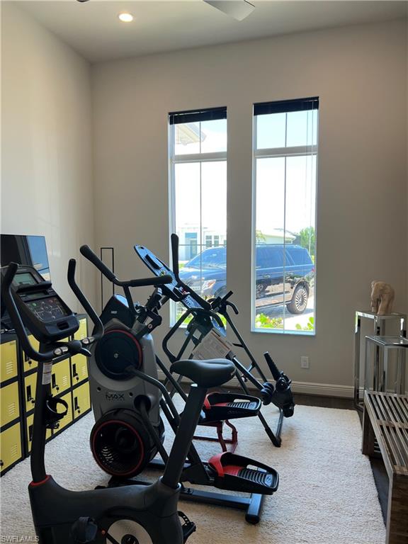 Recessed lighting, ceiling fan, and two tall windows with blinds
