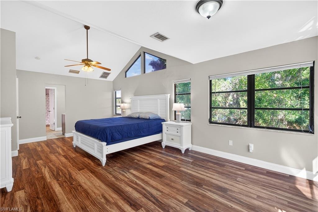 Spacious room featuring wood-finish flooring and a vaulted ceiling with an exposed beam