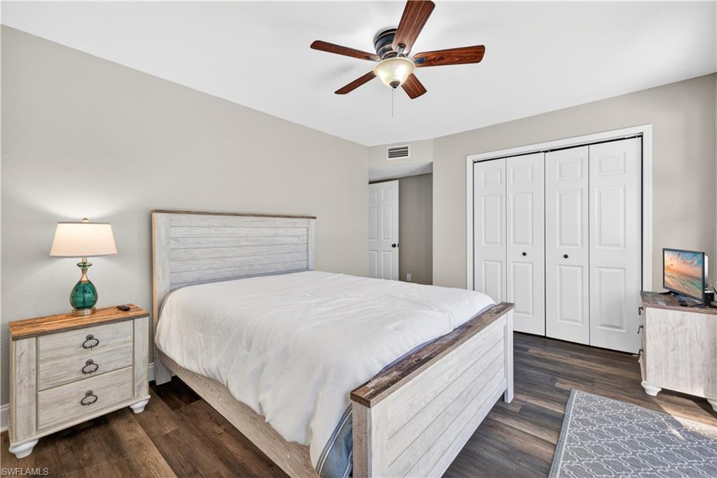 Bedroom featuring wood-finish flooring, a ceiling fan with integrated lighting, and neutral wall tones