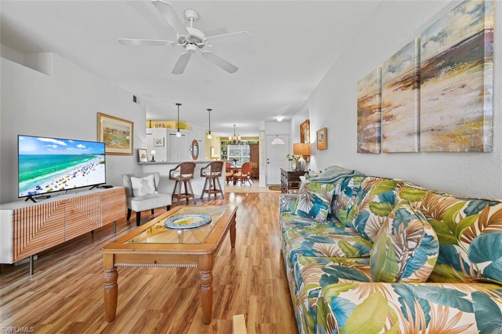 Living room with light wood-type flooring and ceiling fan