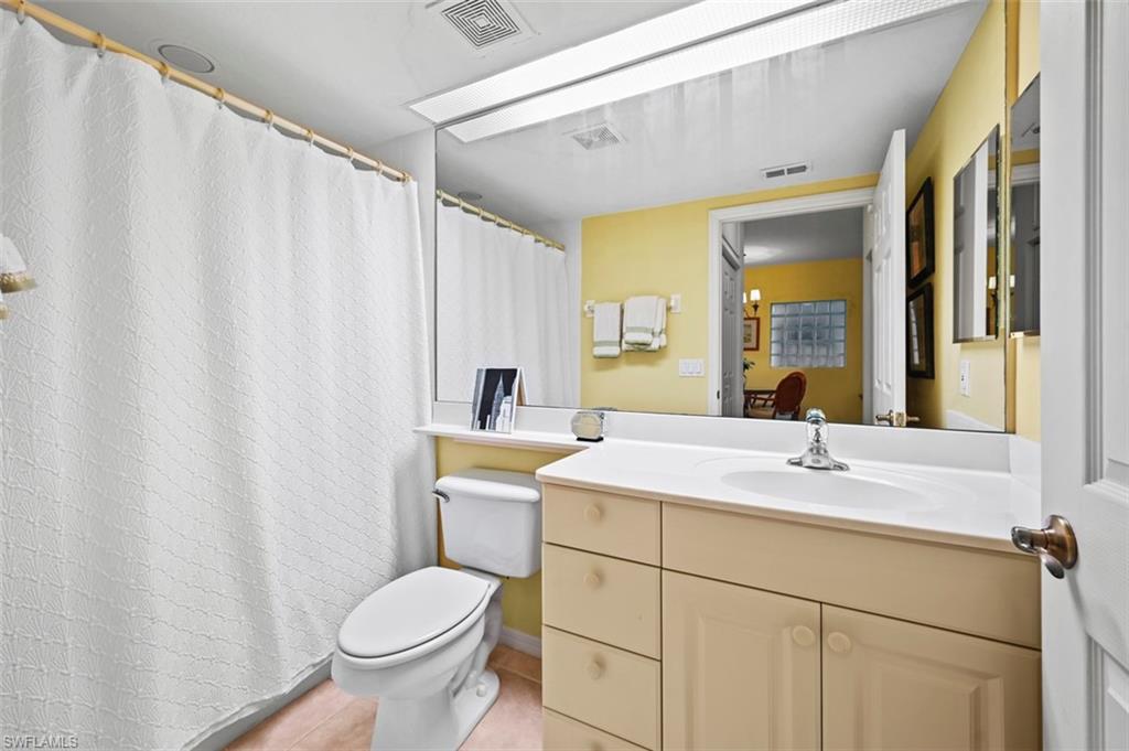 Bathroom featuring vanity, tile patterned flooring, and toilet
