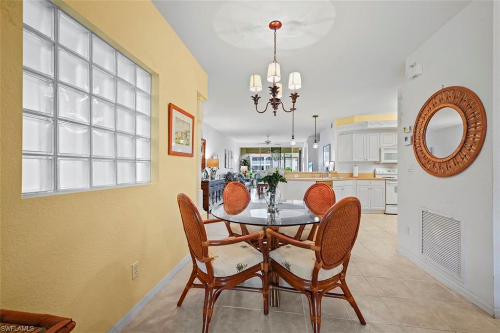 Tiled dining area featuring an inviting chandelier and sink