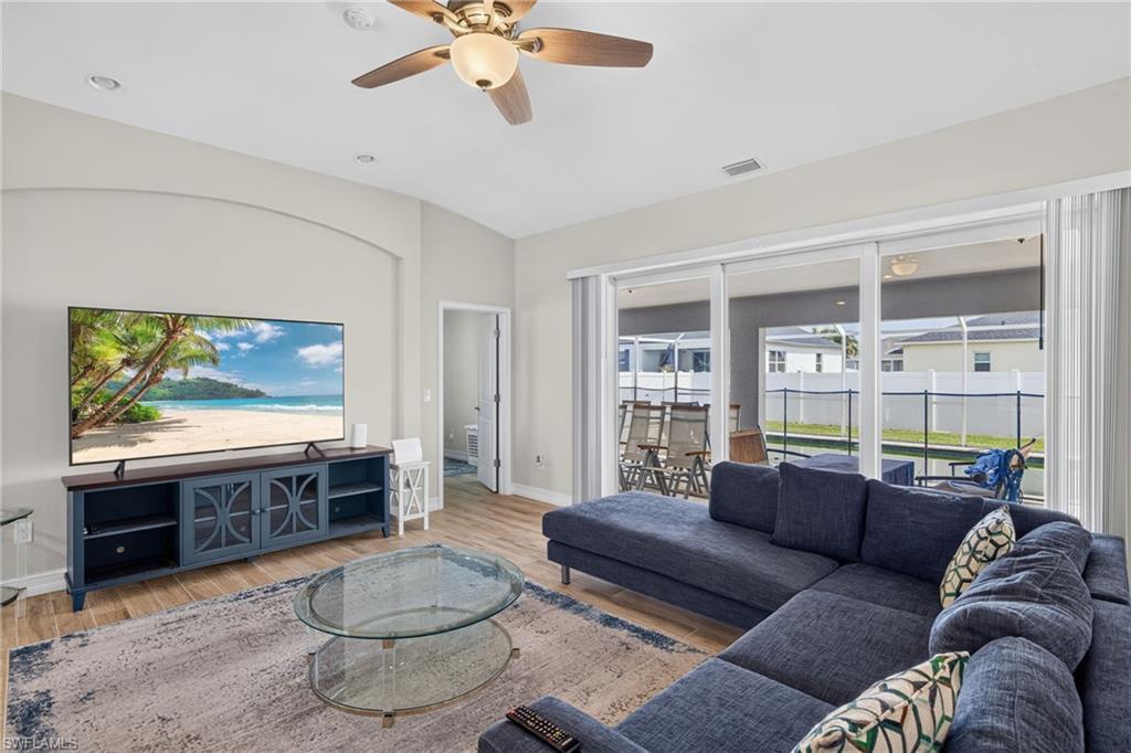 Spacious living area featuring light wood-finish flooring, recessed lighting, and a ceiling fan
