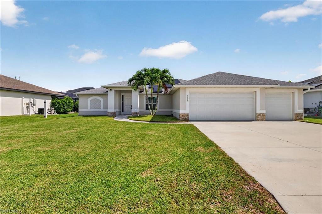 Ranch-style exterior with a three-car garage, concrete driveway, and a front lawn