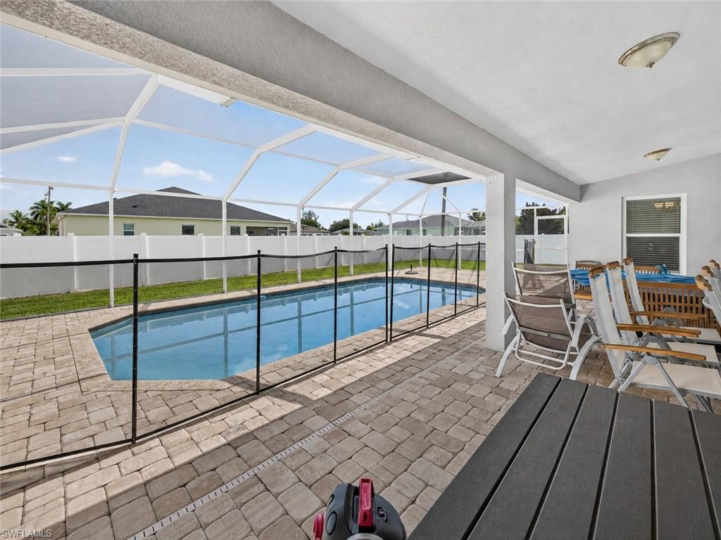 Screened outdoor living area featuring a rectangular pool with safety fencing