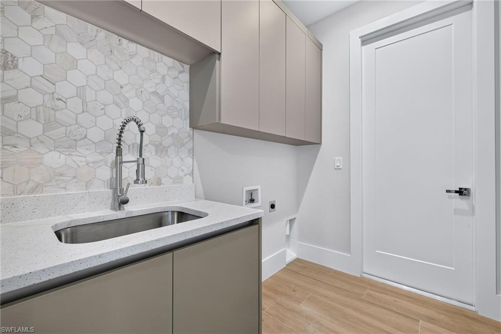 Utility sink with a chrome gooseneck faucet, set within a light-colored countertop