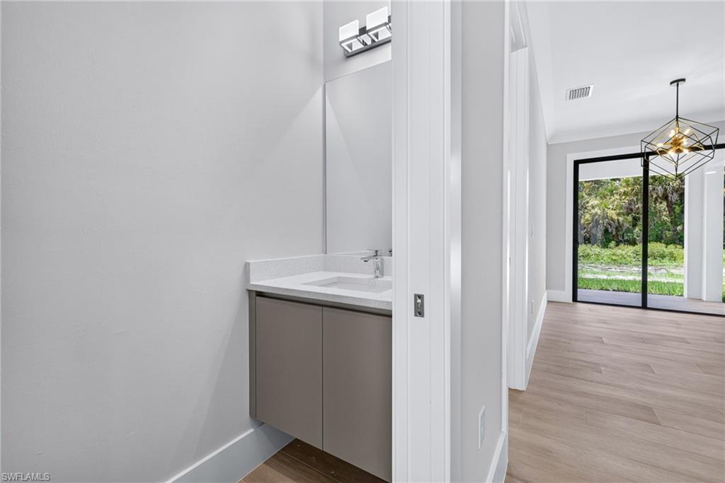 Contemporary vanity featuring an undermount sink, countertop, and mirror with an overhead light fixture