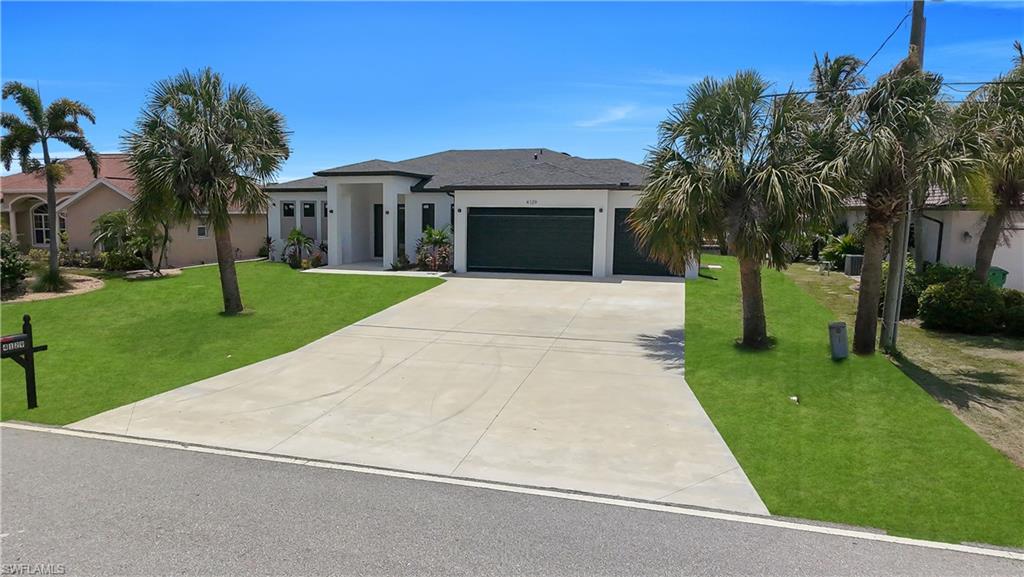 Contemporary single-story residence with a dark shingle roof and a spacious concrete driveway