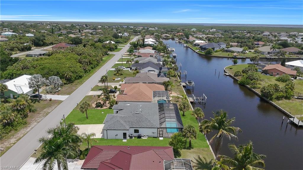 Canal-front property featuring a private boat dock and screened pool enclosure
