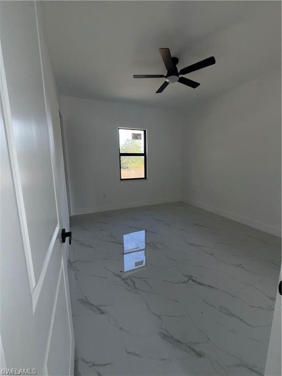 Spacious room featuring large format tile flooring with a marble-effect pattern, a contemporary ceiling fan, and a single window