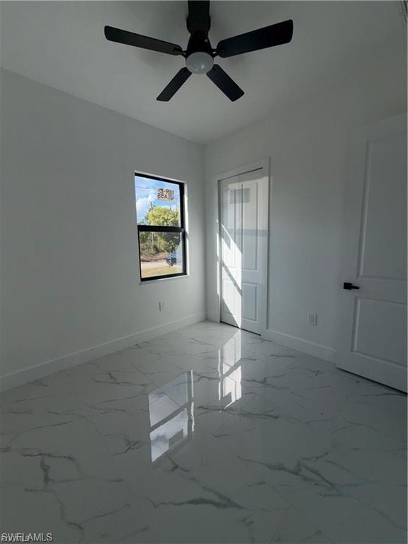 Bright room featuring high-gloss tile flooring, a dark-framed window, a ceiling fan, and a white paneled door with dark hardware
