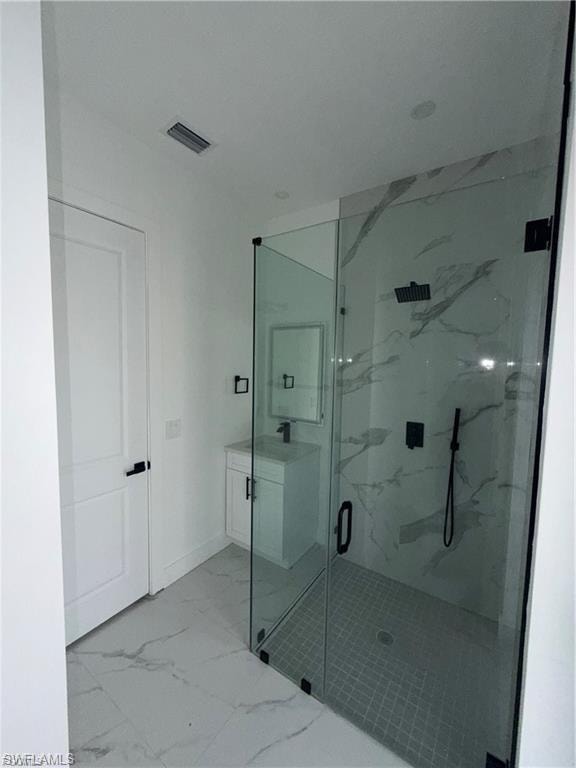 Walk-in shower with clear glass enclosure and black hardware, complemented by large format tile flooring and a white vanity with a rectangular sink
