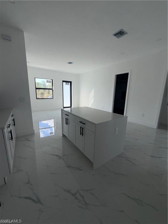 Central kitchen island with white cabinetry and a light-toned countertop
