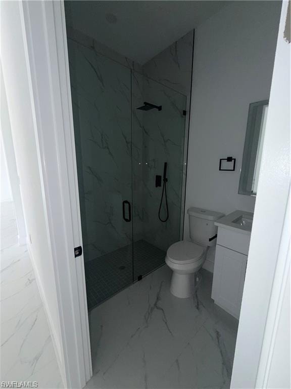Modern bathroom featuring a glass-enclosed shower with black fixtures, a white vanity with integrated sink, and white-patterned tile flooring