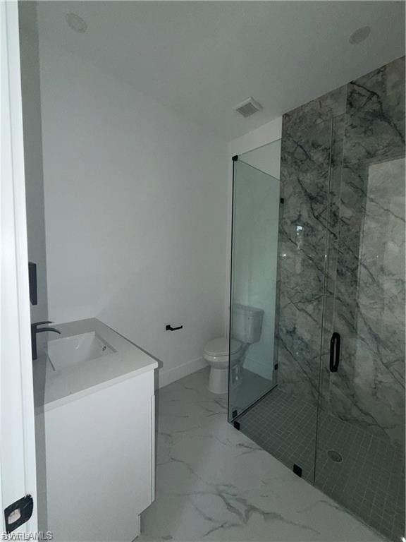 Bathroom featuring a glass-enclosed shower with marble-look tile, a white vanity with an integrated sink, and large format marble-look floor tile