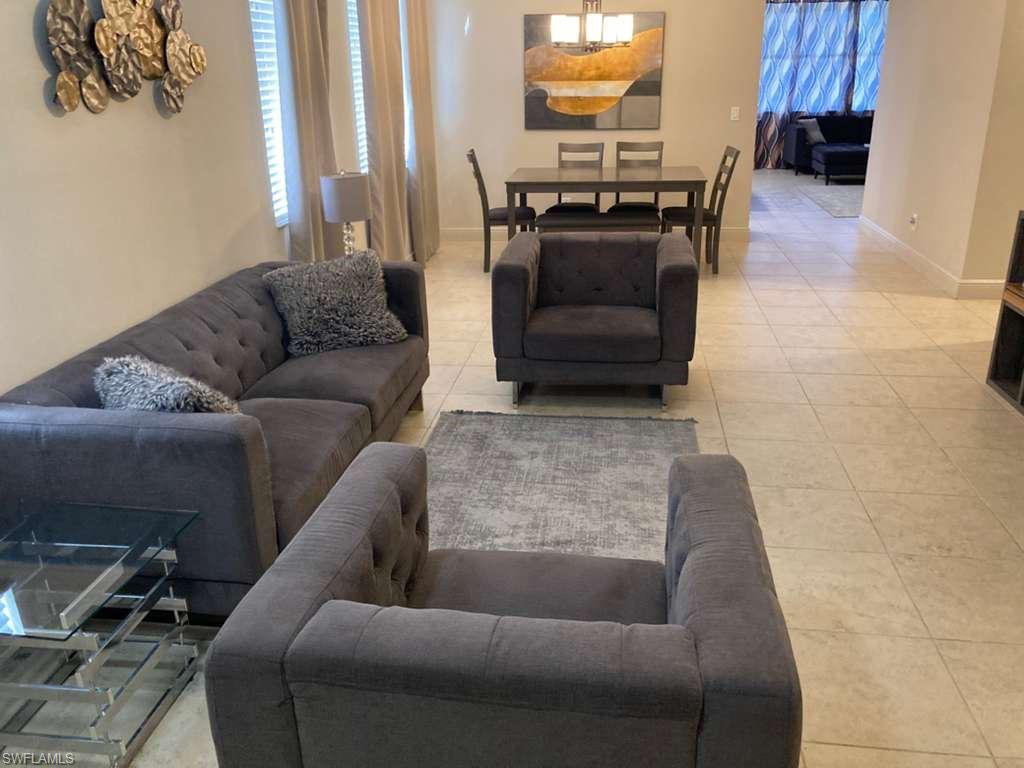 Open-concept living area featuring tile flooring, neutral wall tones, and recessed lighting
