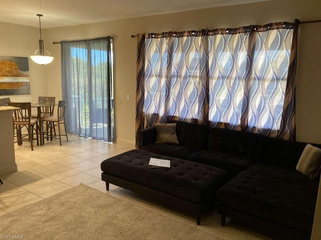 Open concept living space featuring tile flooring and a patio door with sheer curtains