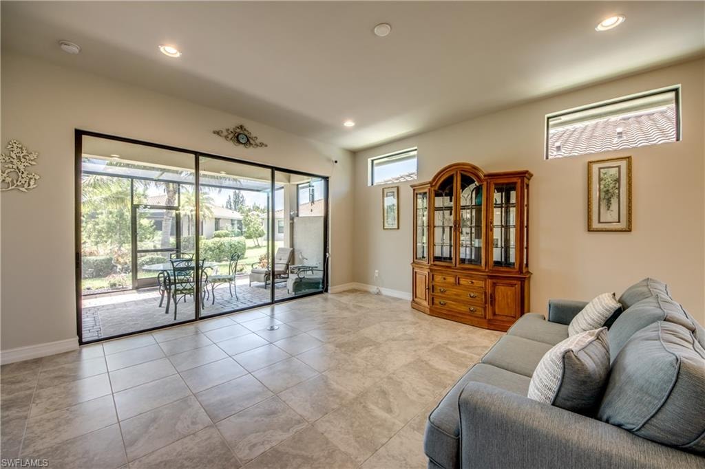 Spacious room featuring large format tile flooring, recessed lighting, and high ceilings