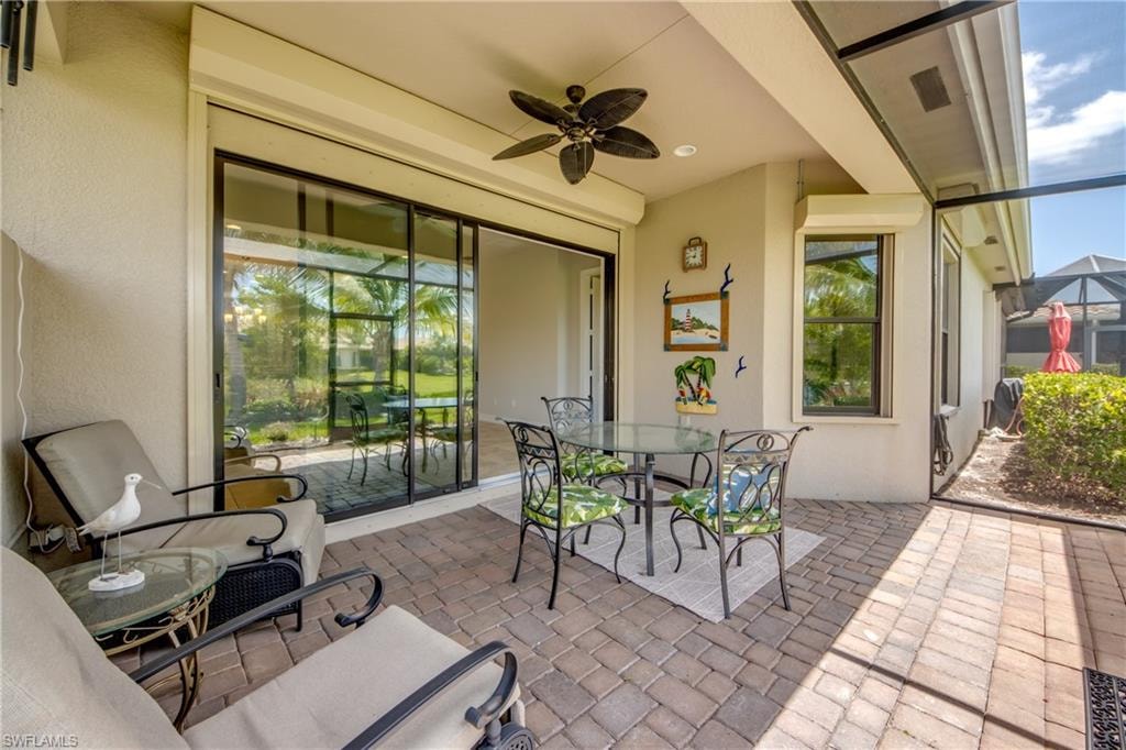 Screened patio featuring paver flooring, overhead ceiling fan, and sliding glass doors