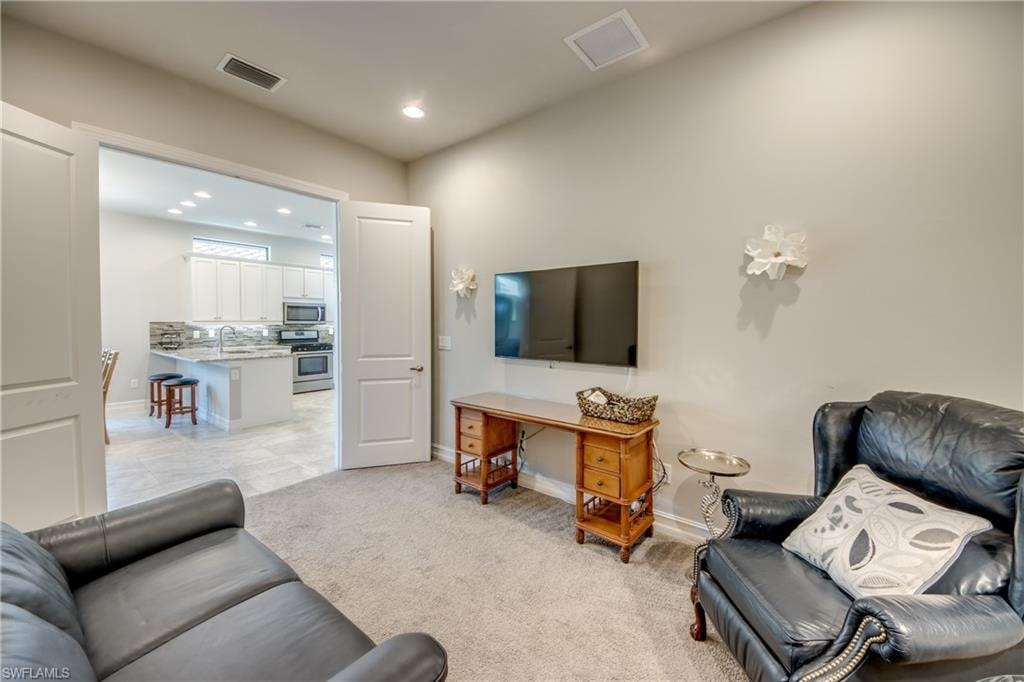 Living area featuring light-toned carpeting and neutral wall paint
