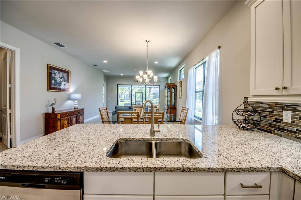 Kitchen island featuring a double basin stainless steel sink with a gooseneck faucet