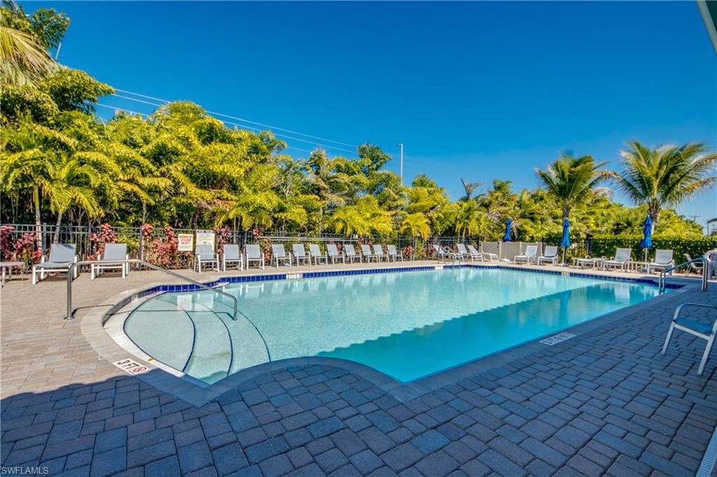 Outdoor swimming pool featuring a gradual entry, blue tile trim, and surrounding paver decking