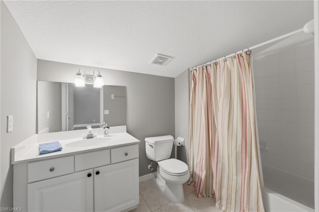 Bathroom in LOFT featuring a white vanity with integrated sink, rectangular mirror, and a built-in tub with tile surround