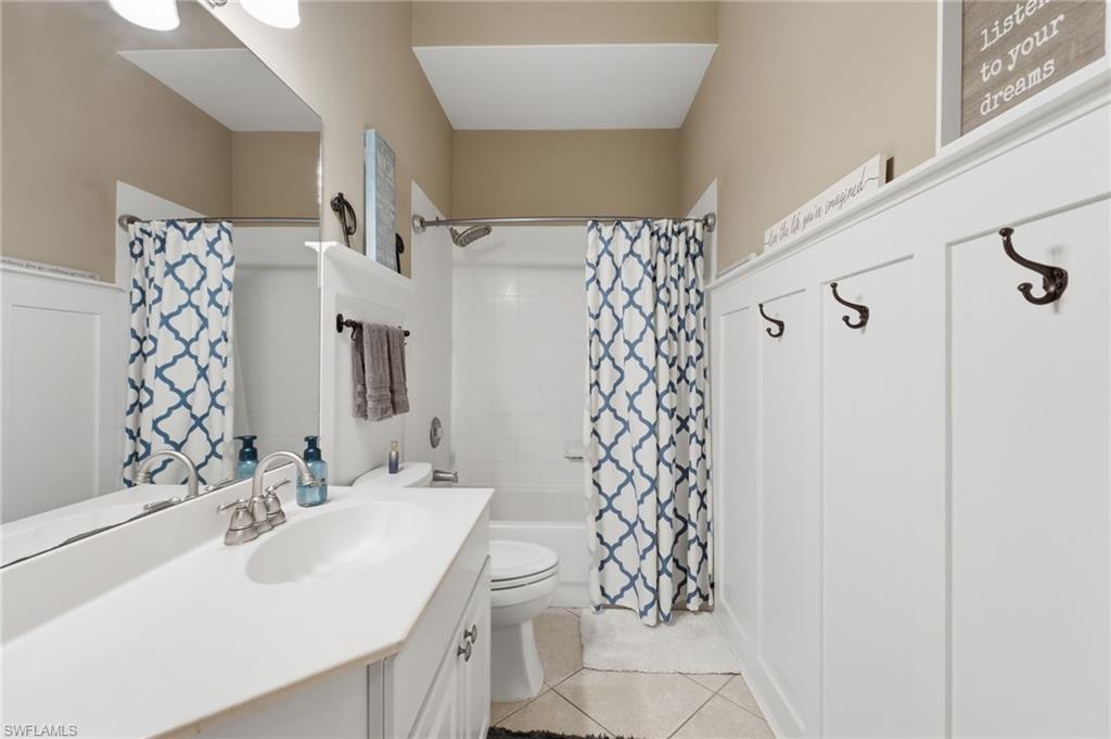 Bathroom featuring a white vanity with an integrated sink, brushed nickel faucet, and a large wall mirror