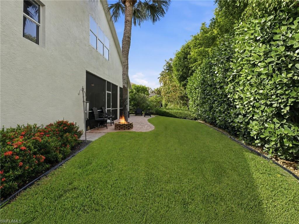 Expansive green lawn bordering a stone paver patio