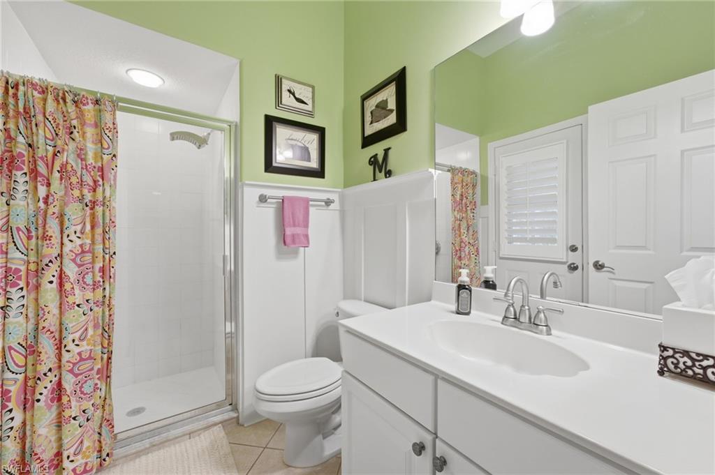 POOL BATH - Bathroom featuring a single vanity with an integrated sink, polished chrome faucet, and a large wall-mounted mirror