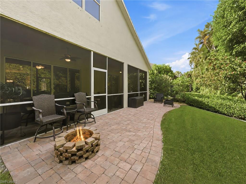 Expansive paver patio featuring a built-in fire pit