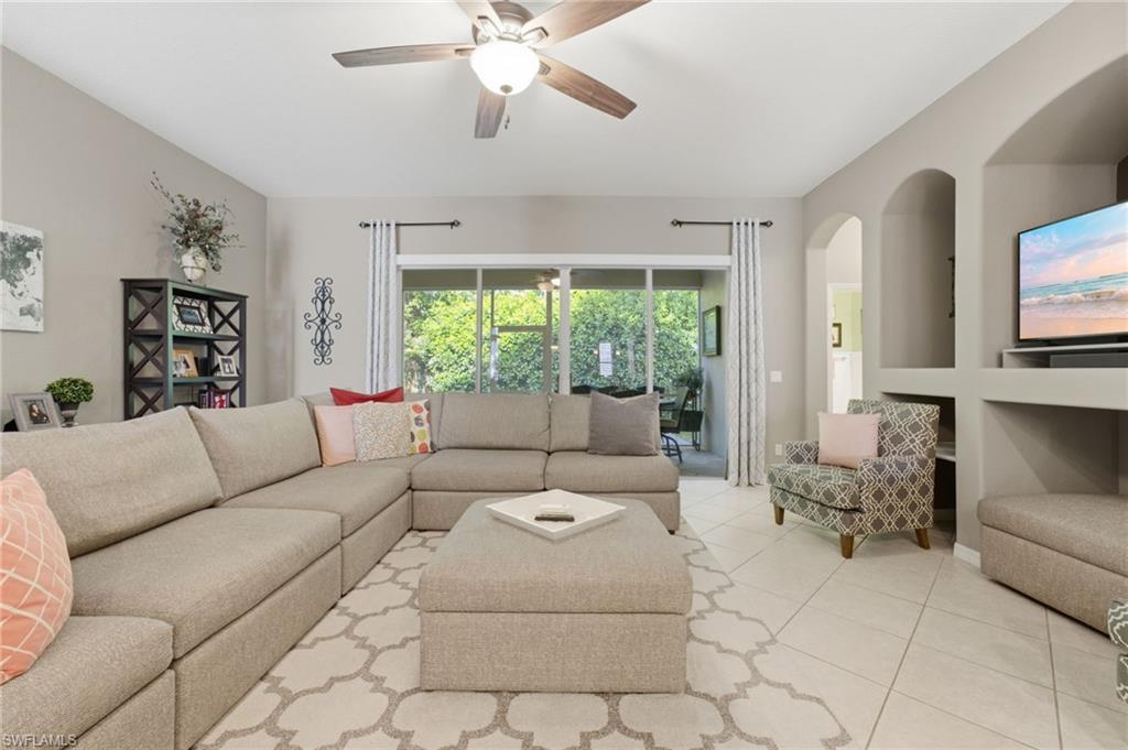 Spacious living area featuring light-toned tile flooring and a ceiling fan