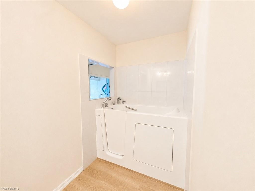 Walk-in tub with chrome fixtures and white subway tile surround