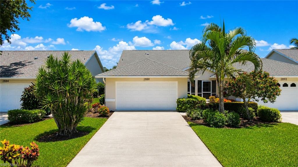 Single-story residence featuring a two-car garage with a white panel door, a grey shingle roof, and a light-colored exterior