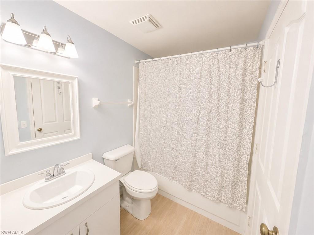 Bathroom featuring a single vanity with an integrated sink, chrome faucet, and white framed mirror